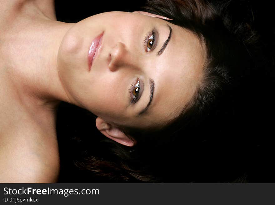 Beautiful brunette laying on a black background. Beautiful brunette laying on a black background.