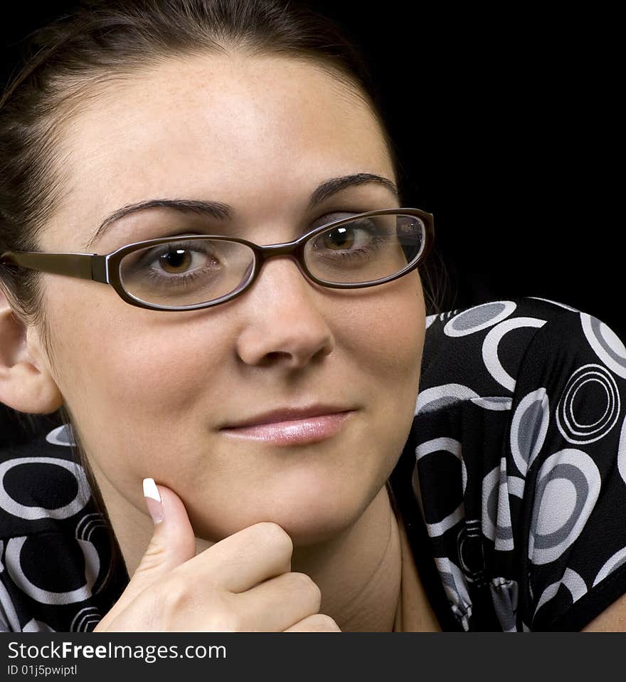 Portrait of a studious looking brunette on a black background. Portrait of a studious looking brunette on a black background.