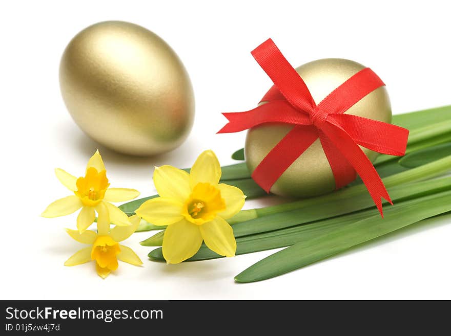 Golden easter eggs wrapped around with red ribbon and daffodils for easter background. Golden easter eggs wrapped around with red ribbon and daffodils for easter background.