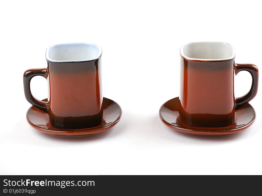 Brown cups for tea and coffee. A small white teapot.