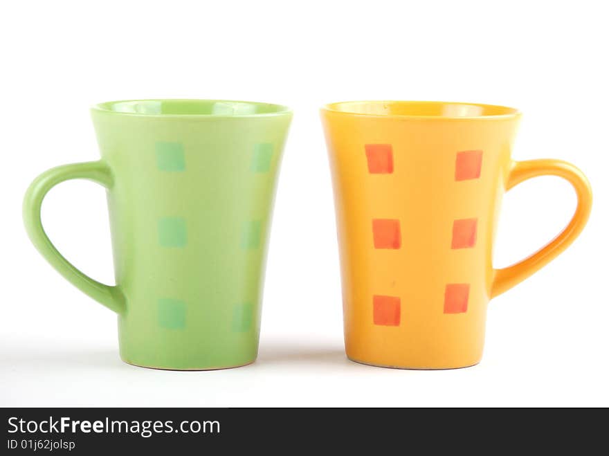 Colour cups for tea and coffee. A small white teapot. Colour cups for tea and coffee. A small white teapot.