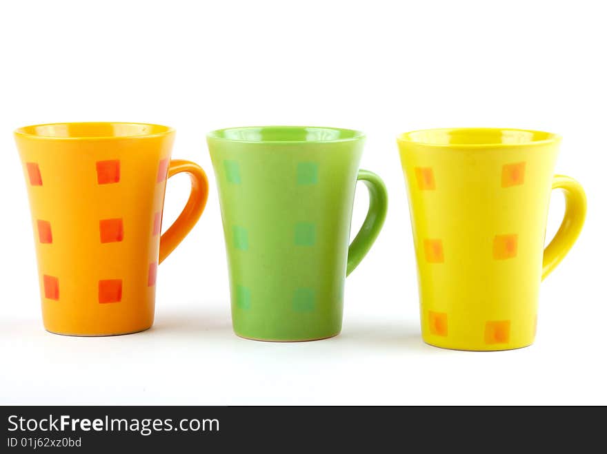 Colour cups for tea and coffee. A small white teapot. Colour cups for tea and coffee. A small white teapot.