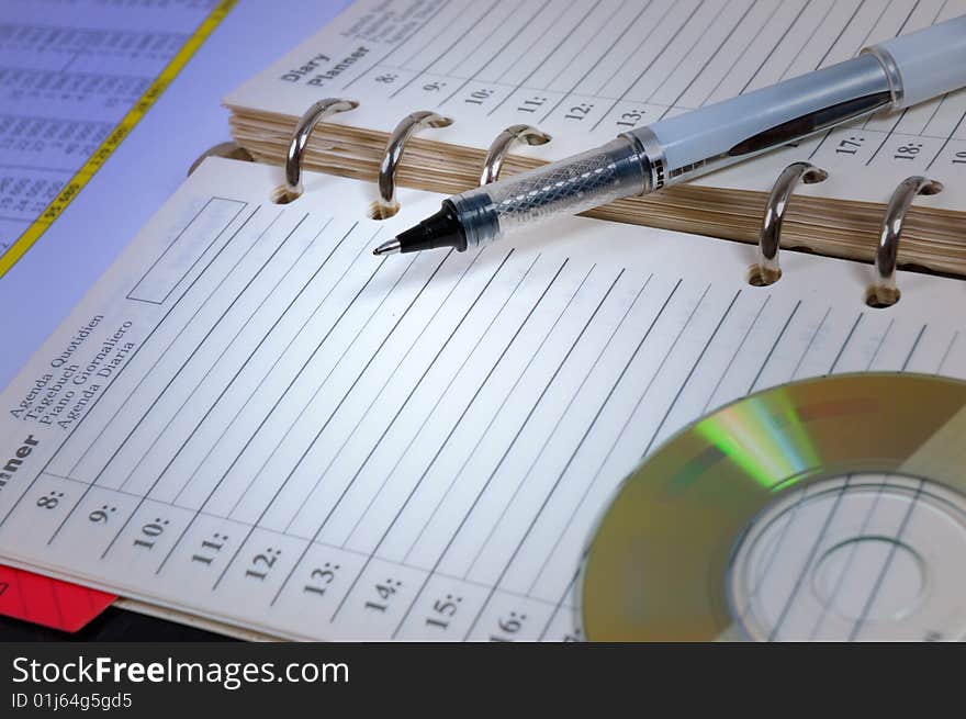 Pen and cd atop of the opened notebook. Pen and cd atop of the opened notebook