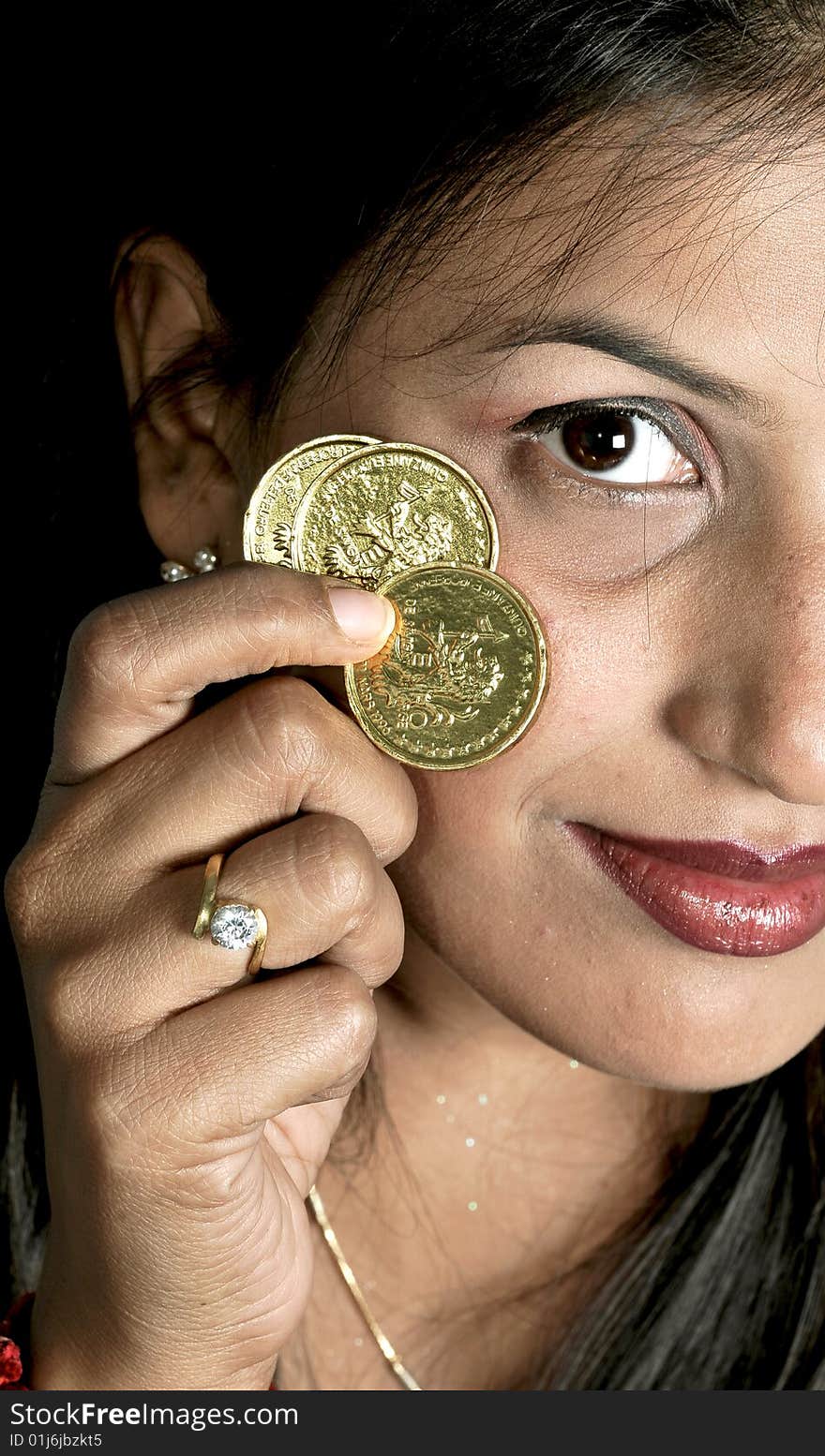 Girl holding gold coins in studio. Girl holding gold coins in studio.