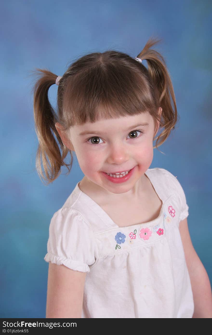 Portrait of a young girl on a blue background. Portrait of a young girl on a blue background.