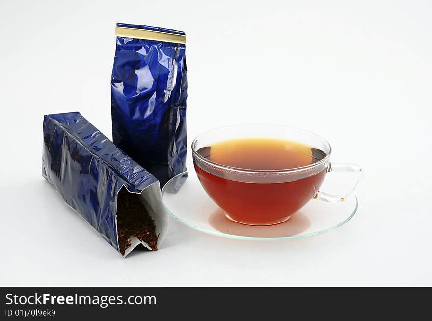 One tea cup and two blue shiny tea bags on white background