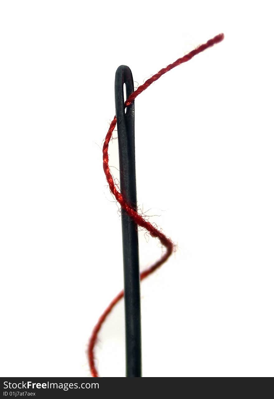 Macro of a needle with a red thread isolated over white. Macro of a needle with a red thread isolated over white.