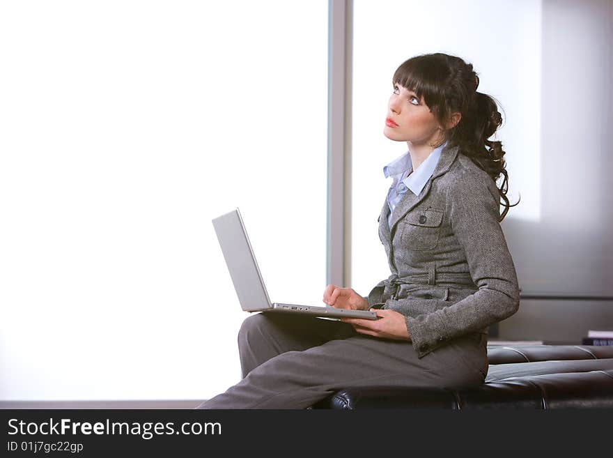 Business woman thinking in modern office with laptop. Business woman thinking in modern office with laptop