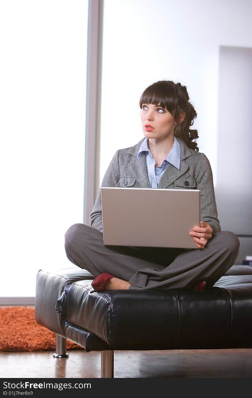 Business woman thinking in modern office with laptop. Business woman thinking in modern office with laptop