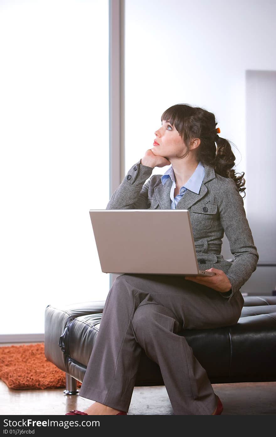 Business woman thinking in modern office with laptop. Business woman thinking in modern office with laptop