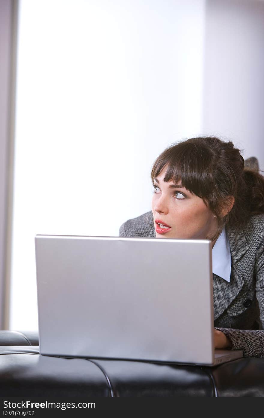 Business woman thinking in modern office with laptop. Business woman thinking in modern office with laptop