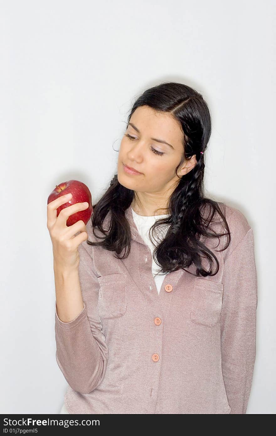 Portrait of smiling young woman holding apple, isolated on white background