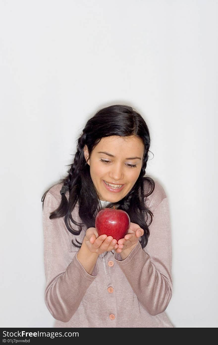 Portrait of smiling young woman holding apple, isolated on white background