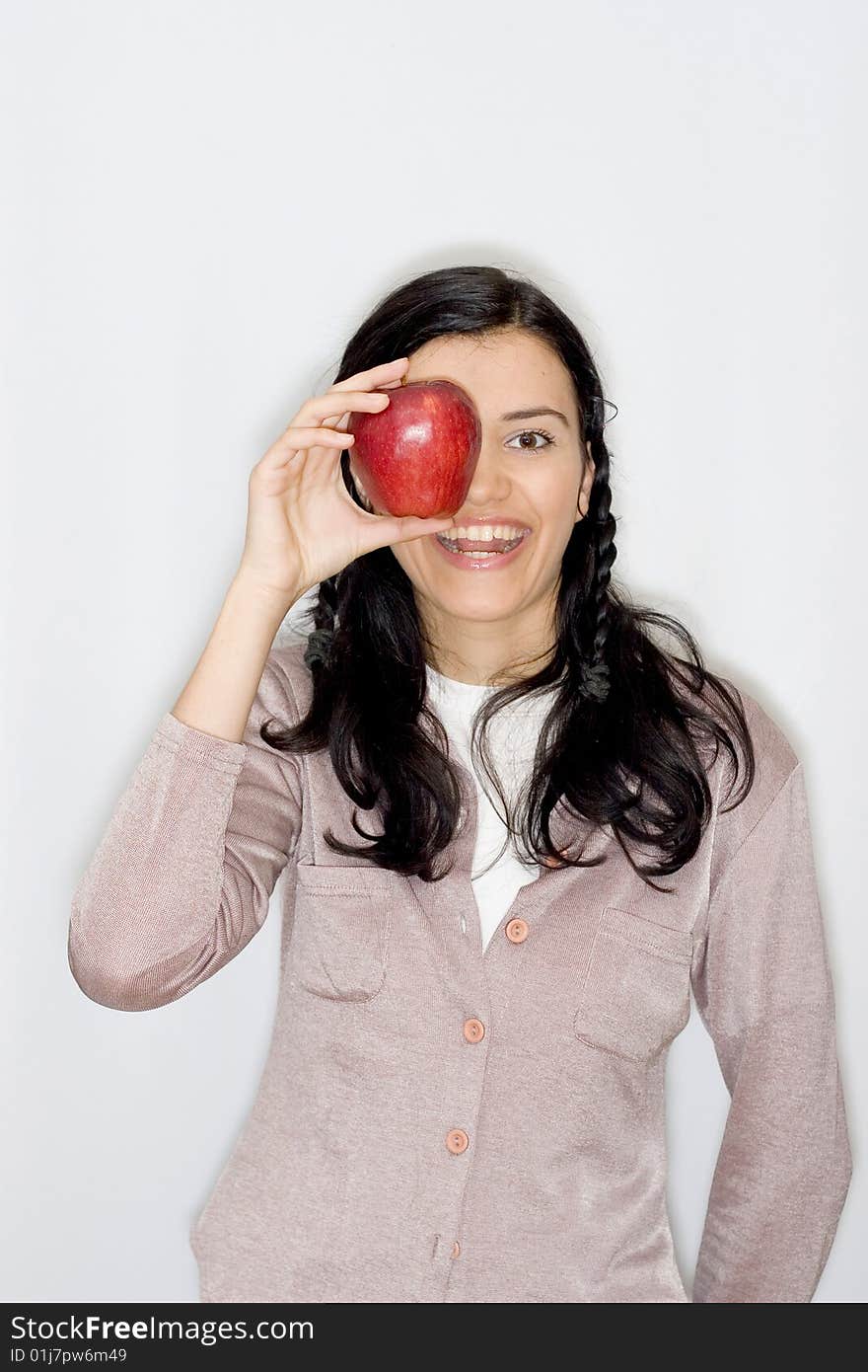 Portrait of smiling young woman holding apple, isolated on white background