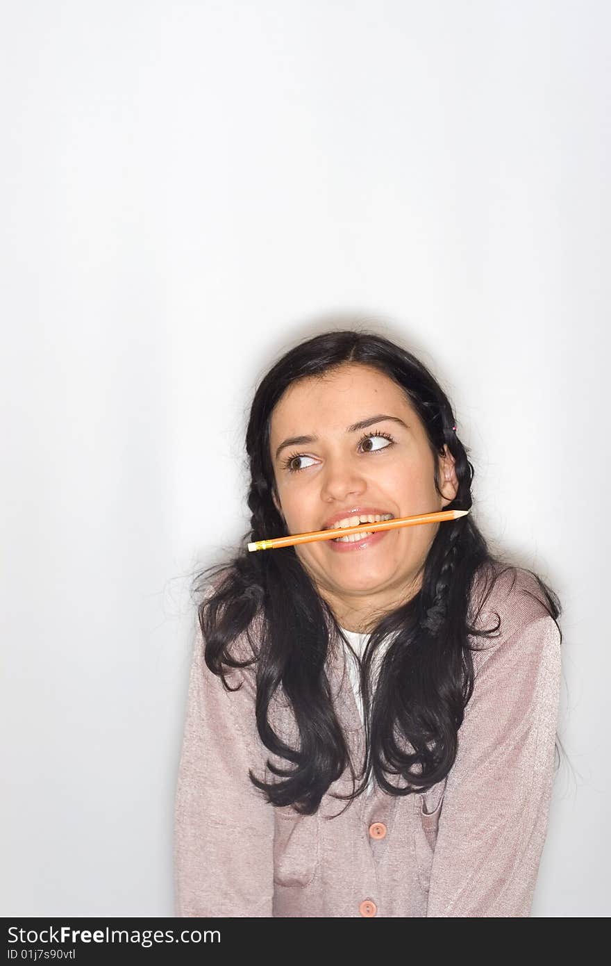 Young woman with pencil in her mouth