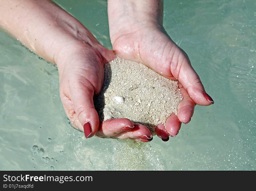 Woman's hands with sand at the beach. Woman's hands with sand at the beach.