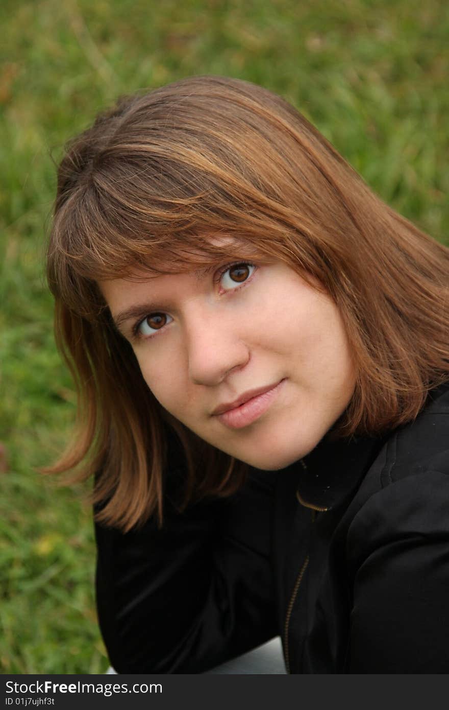 A girl on the green grass background smilling. A girl on the green grass background smilling