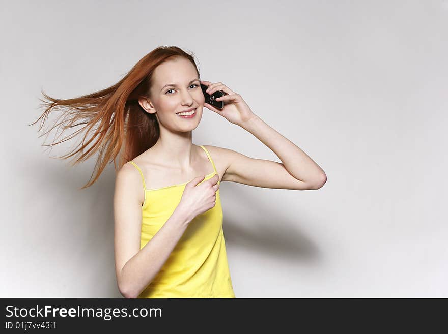 The young beautiful woman talks by a mobile phone. The young beautiful woman talks by a mobile phone