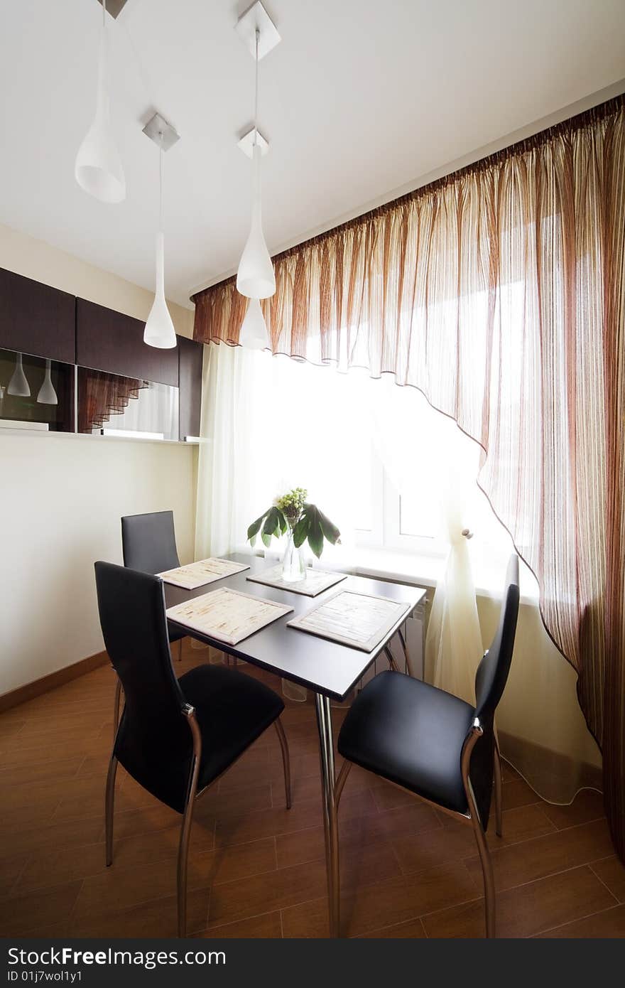 Table and chairs by the window on the modern kitchen