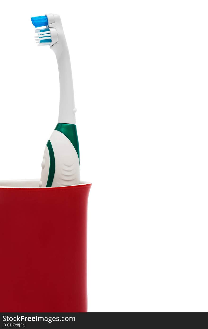 Toothbrush in a red glass on a white background