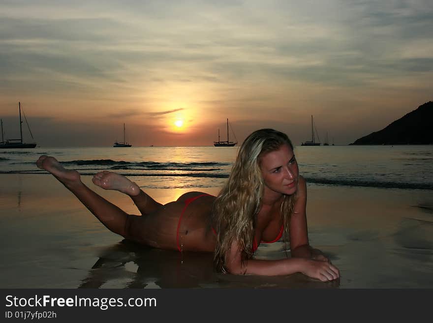 Blonde girl lying on the sand beach. Blonde girl lying on the sand beach