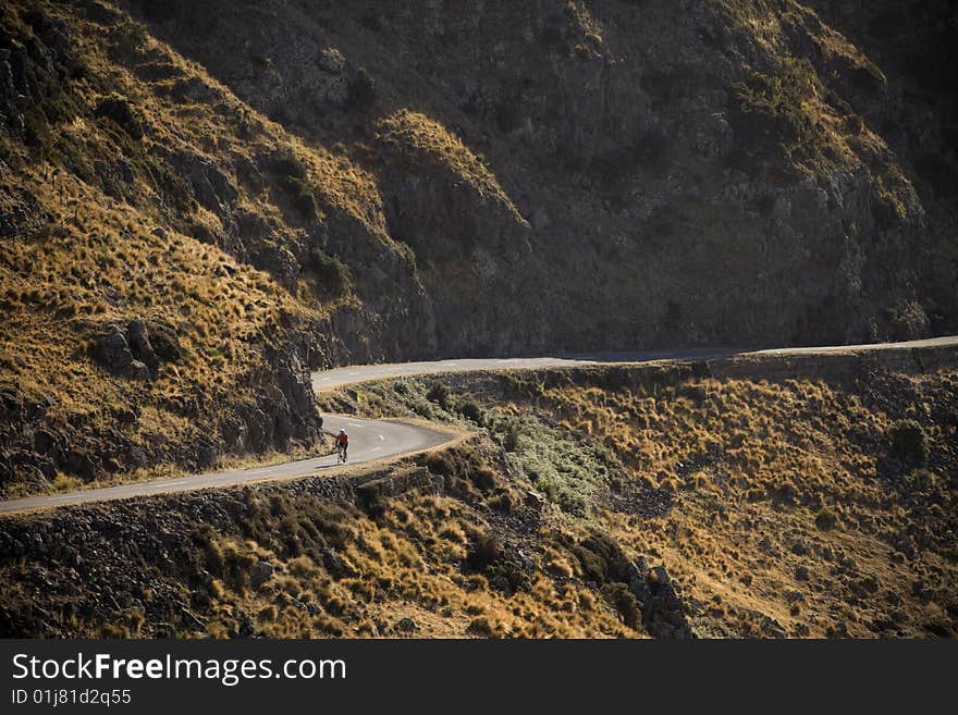 A cyclist on a winding road. A cyclist on a winding road