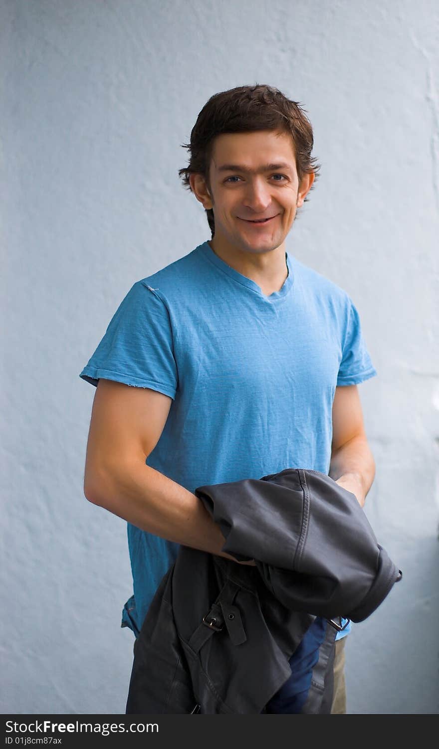 The young smiling person in a blue T-shirt. The young smiling person in a blue T-shirt.