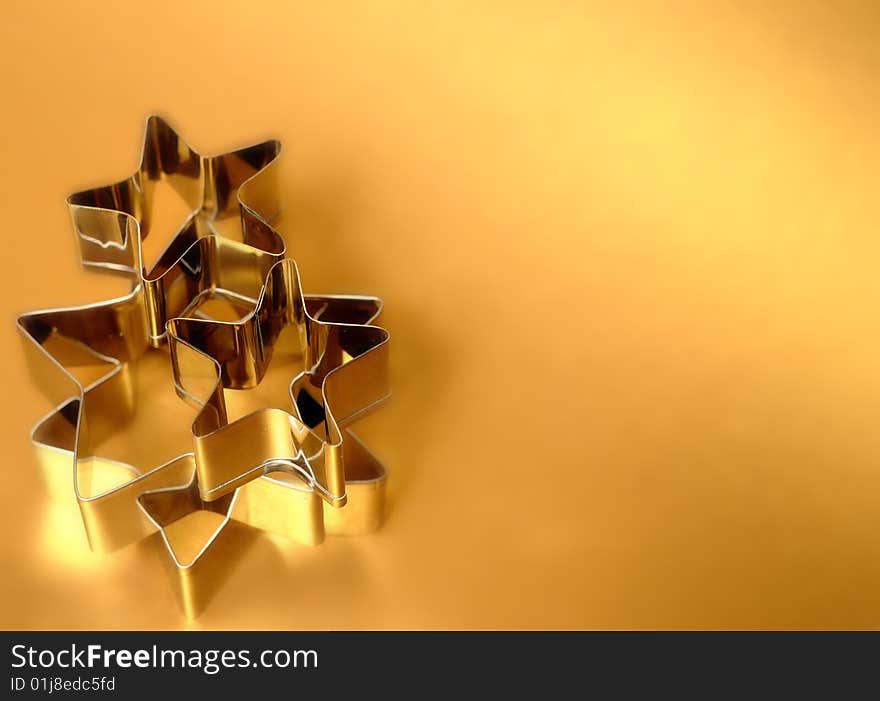 Silver star shaped cookie cutters on gold