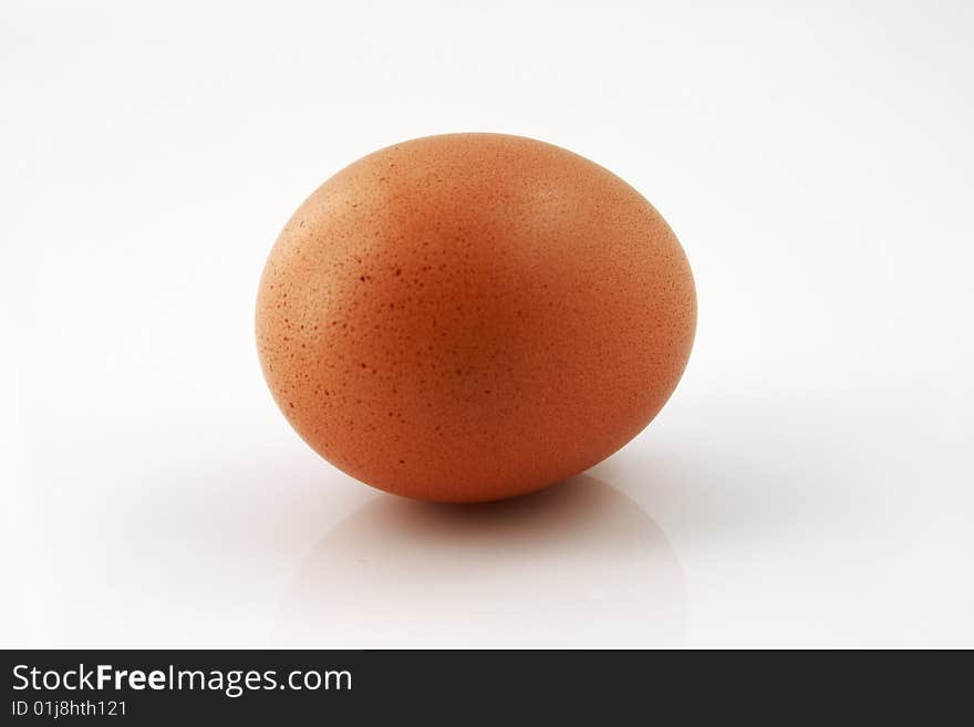 A closeup of an uncracked egg on a white background