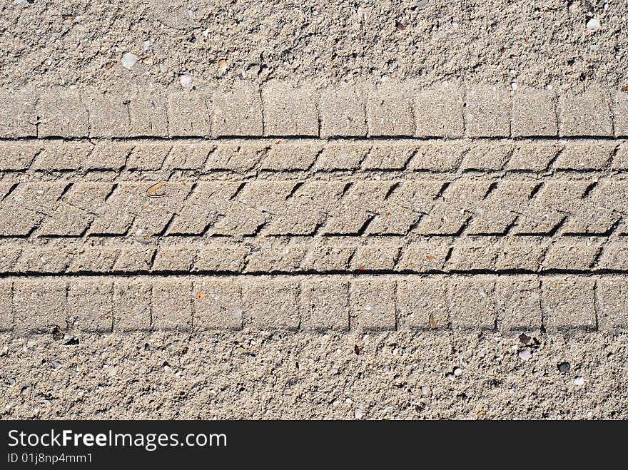 Sand with tyre tread for use as background.