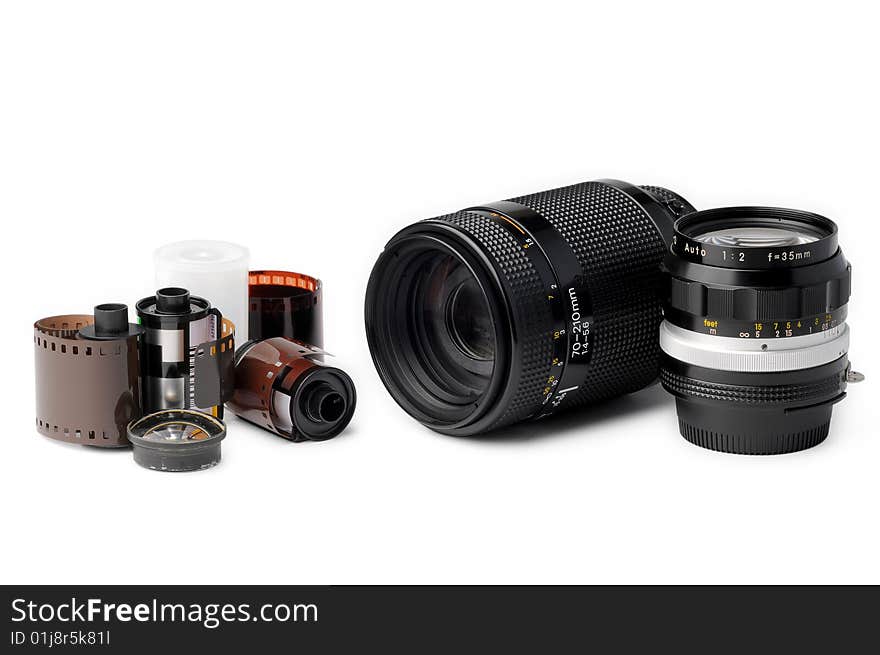 Two camera lenses and film rolls on white background