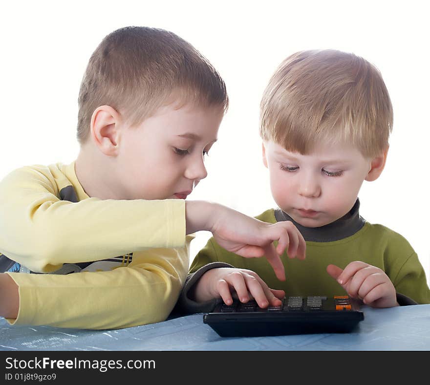 Two children of the boy play with the calculator. Two children of the boy play with the calculator