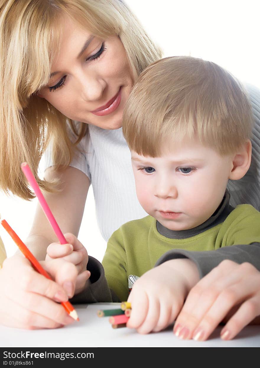 The little boy draws pencils with mum. The little boy draws pencils with mum