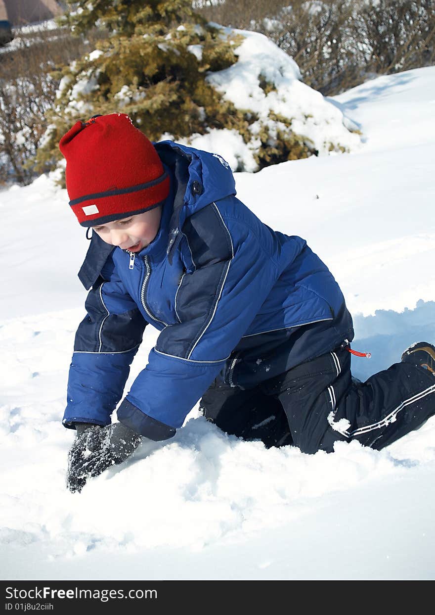 The child the boy plays in the winter in the street