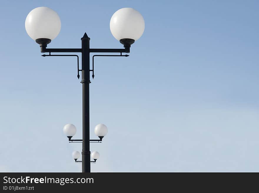 Lampposts standing in a row against the blue sky