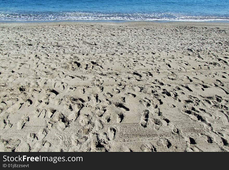 Footprints on a beach, at the background the sea