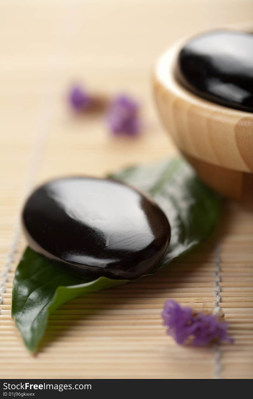 Black zen stones in wooden bowl. spa background