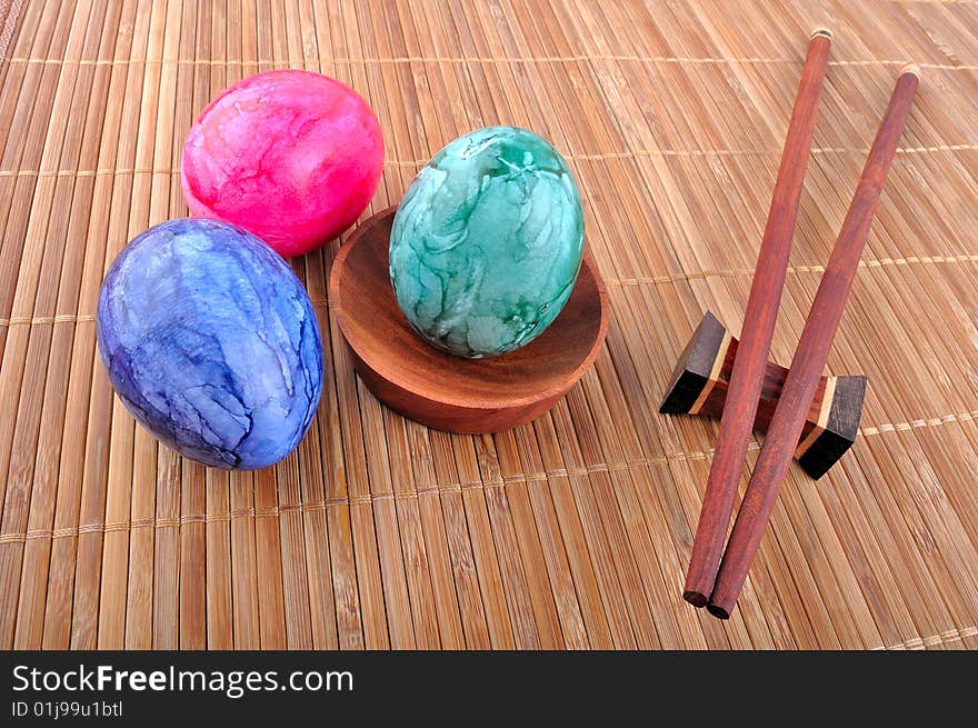 Easter eggs and chopsticks on bamboo strips of paper.