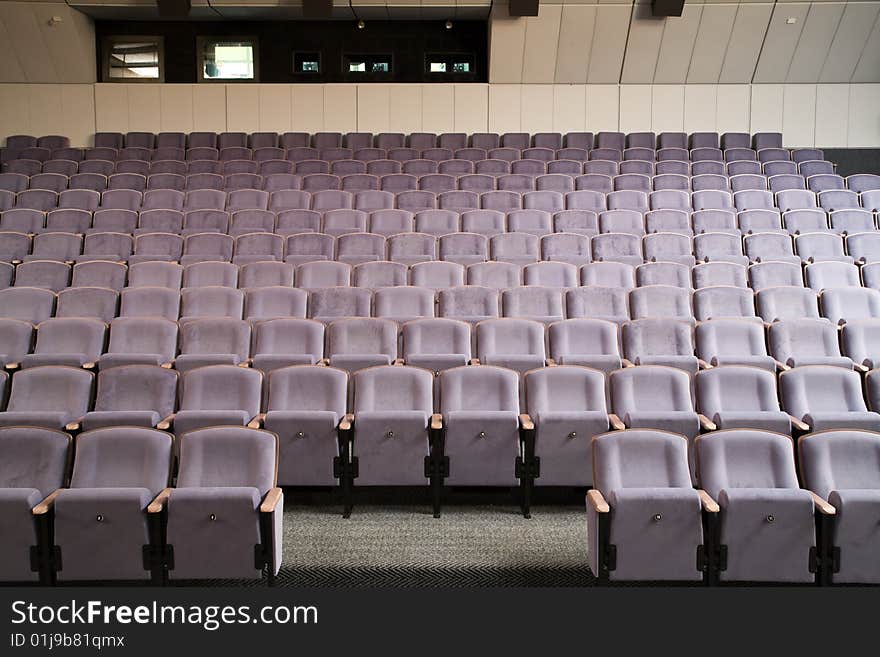 Empty new cinema auditorium with rows of violet blue chairs. Empty new cinema auditorium with rows of violet blue chairs.