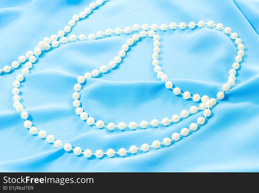 Photo of blue silk texture and pearls