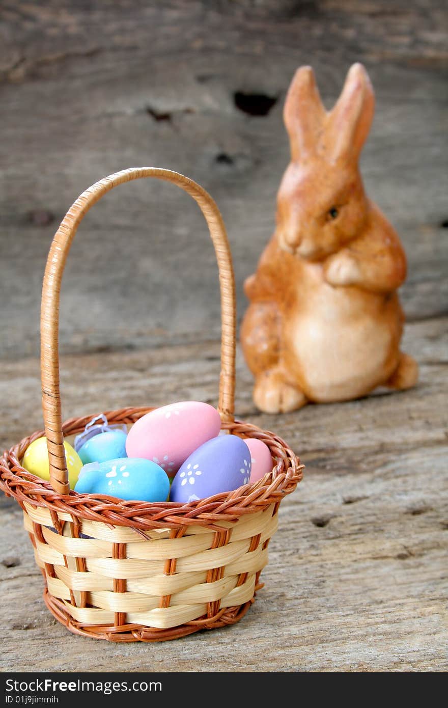 An Easter basket full of tiny and colorful eggs with a bunny in the background.  Used a shallow depth of field and selective focus. An Easter basket full of tiny and colorful eggs with a bunny in the background.  Used a shallow depth of field and selective focus.