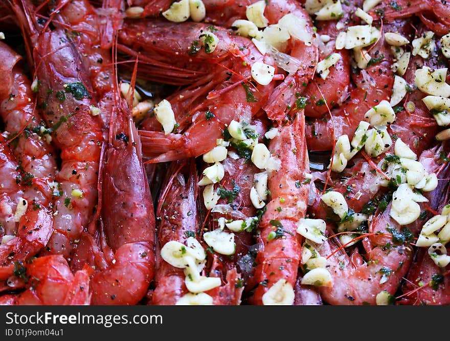 cooked king prawns, some with some without skin, prepared with garlic and herbs