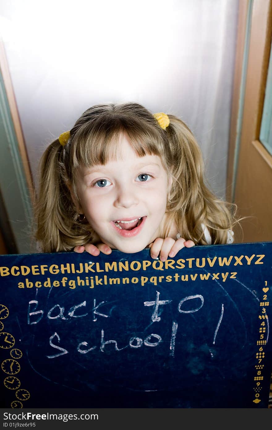 An image of a nice girl looking from behind a  blackboard. An image of a nice girl looking from behind a  blackboard