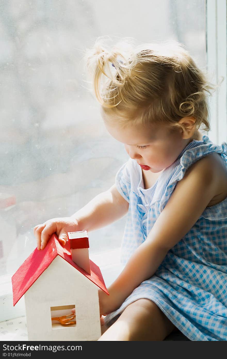 An image of a cute baby with little house