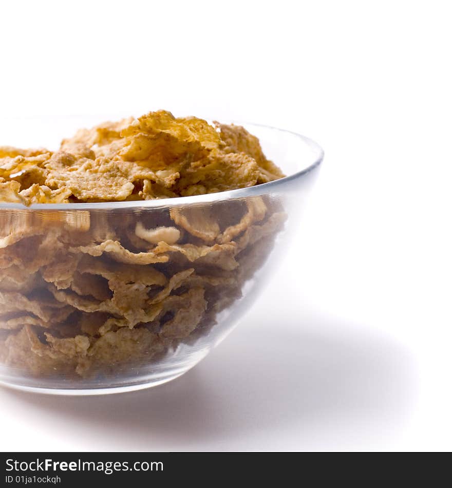 Glass bowl full of cornflakes on white closeup on white