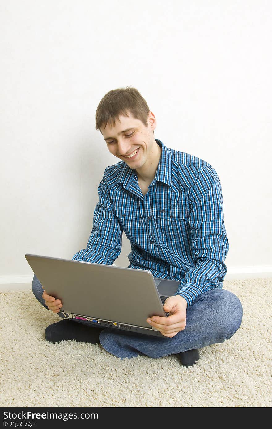 Man sitting on the floor using a laptop