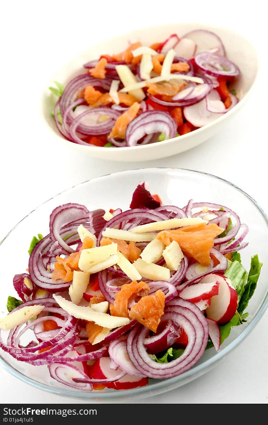 Two salad plates on white background, focus on first salad