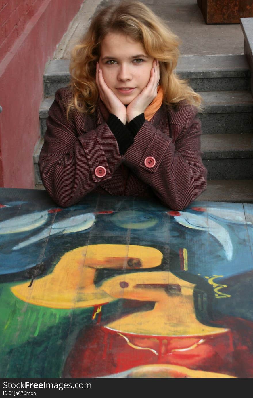 Smiling girl sitting near graffiti. Smiling girl sitting near graffiti