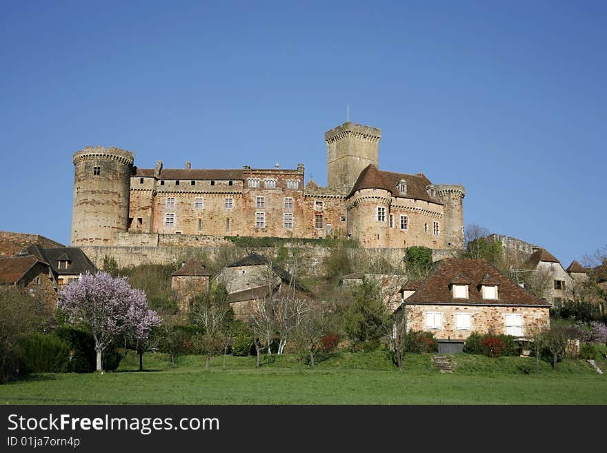 Castle and old village of Bretenoux in green fields, France. Castle and old village of Bretenoux in green fields, France