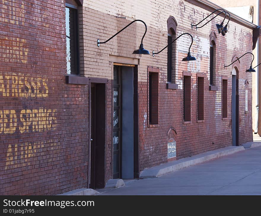 Urban renewal old store building in an alley. The building is red brick and has faded advertising painted on the wall. This is one of two perspective views. Urban renewal old store building in an alley. The building is red brick and has faded advertising painted on the wall. This is one of two perspective views.